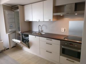 a kitchen with white cabinets and a sink at Wenduine op zeedijk in Wenduine
