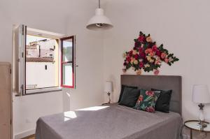 a bedroom with a bed with a flower arrangement on the wall at Casa Porta D`Aviz in Évora