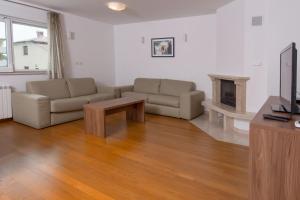 ein Wohnzimmer mit einem Sofa und einem Tisch in der Unterkunft Deluxe Apartment with private Pool - 100m from the sea in Pula