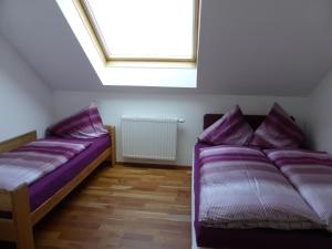 1 dormitorio con 2 camas con sábanas moradas y tragaluz en Luxusappartement Haus 157, en Mauterndorf