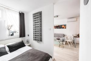 sypialnia z łóżkiem i salon ze stołem w obiekcie Alma Apartments Grzybowska w Warszawie