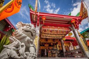 a temple with a lion statue in front of it at Phuket Sunny Hostel in Phuket Town