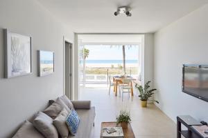 a living room with a couch and a view of the ocean at Sunny Beachfront Escape in Castelldefels