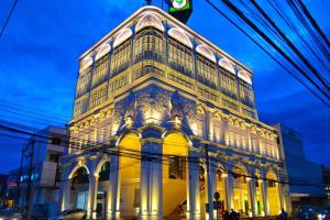 a large building is lit up at night at Phuket Sunny Hostel in Phuket Town