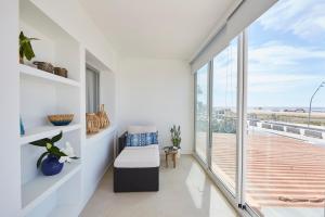 a living room with a bench and a large window at Sunny Beachfront Escape in Castelldefels