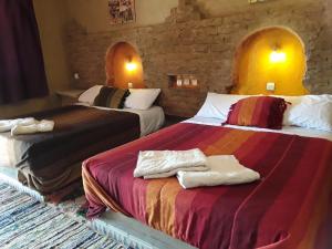 ein Hotelzimmer mit 2 Betten und Handtüchern darauf in der Unterkunft Auberge Camping La Liberté in Merzouga