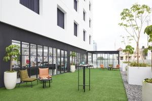 an internal courtyard of a building with chairs and tables at de Braga, ARTOTEL Curated in Bandung