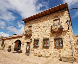 an old stone building with windows and a balcony at Casa Pepa Hotel Rural in Santa Colomba de Somoza