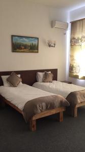 two beds in a hotel room with at Комплекс відпочинку "Колиба" in Korostenʼ
