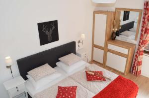 Schlafzimmer mit einem Bett mit roten Kissen und einem Spiegel in der Unterkunft Haus Susanne in Radstadt