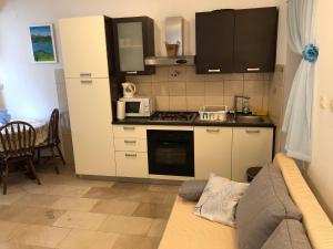 a small kitchen with a stove and a microwave at Apartments Maria in Supetar +30 photos