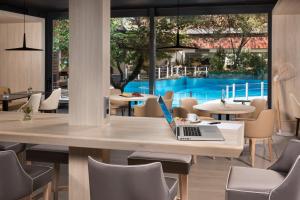 a dining room with a table with a laptop on it at Melia Castilla in Madrid