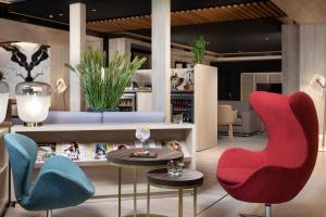 a lobby with colorful chairs and a table at Melia Castilla in Madrid