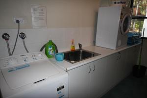 a kitchen with a sink and a washing machine at Beachcomber in Rainbow Beach