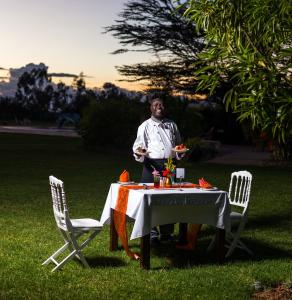 马查科斯Oldonyo Sapuk Resort的坐在桌椅旁的人