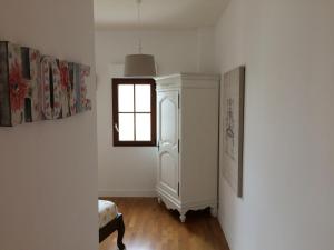 um quarto com um armário branco e uma janela em LA VILLA BOLERO em Saint-Cyr-sur-Loire
