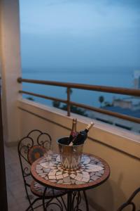 una mesa con 2 botellas de vino y copas en el balcón en Kinorot Hotel, en Tiberíades