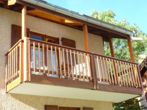 a balcony of a house with a dog sitting on it at Chez Philippe - Appartements et Chalets - Panoramic Village vue Glaciers in La Grave