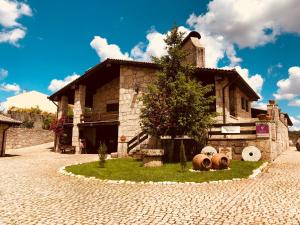 una casa con dos grandes barriles delante de ella en Quinta da Amoreira, en Covilhã