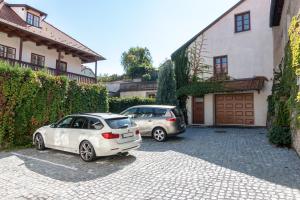 two cars parked in a driveway next to a house at Familia in Český Krumlov