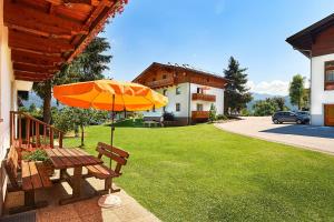 a picnic table with an umbrella in a yard at Sonnberg Ferienanlage in Flachau