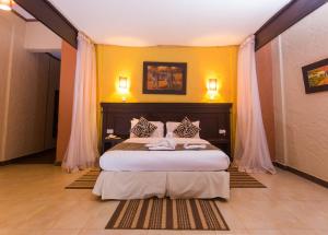 马查科斯Oldonyo Sapuk Resort的一间卧室设有一张黄色墙壁的大床 更多23张照片