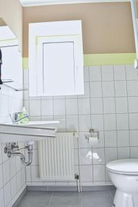 uma casa de banho com um lavatório e um WC em Blechleppel - Die Pension im Harz em Benneckenstein