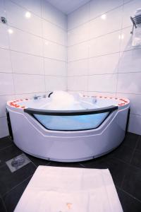 a white bath tub in a white tiled bathroom at Grand Gabriel in Jounieh
