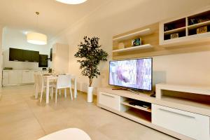 a living room with a television and a dining room at Luxury Apartment with Pool in Sliema