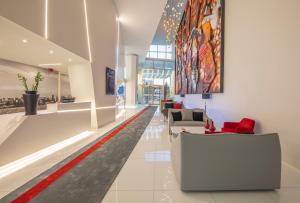 a lobby with a waiting area with red chairs at Meliá Maputo Sky in Maputo