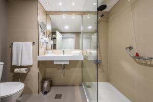 
a bathroom with a toilet, sink, and shower at Enotel Sunset Bay in Ponta do Sol
