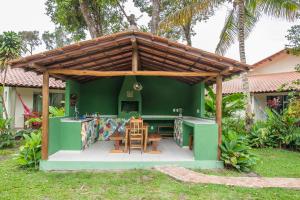 uma cozinha verde com uma pérgola de madeira em Pousada Peki em Arraial d'Ajuda