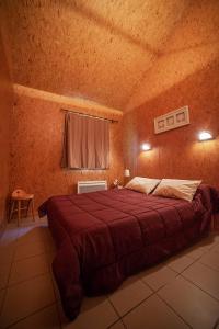 a bedroom with a large red bed in a room at Le Pas de L'Ours in Aston +31 photos