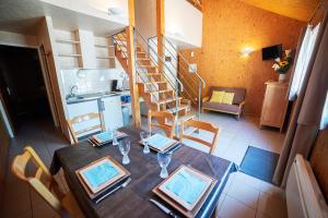 a dining room table and a kitchen with a staircase at Le Pas de L'Ours in Aston