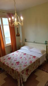 1 dormitorio con 1 cama con manta de flores en Casolare Al Dopolavoro, en Lucca