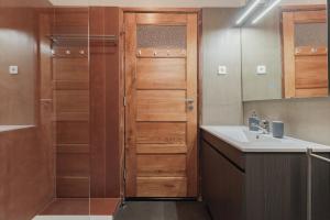 a bathroom with a sink and a wooden door at Puro Apartment in Porto +39 photos