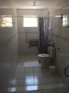 a bathroom with a toilet and a shower curtain at Vinte Park Hotel in Bragança Paulista