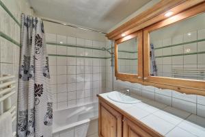 La salle de bains est pourvue d'un lavabo, d'une baignoire et d'une douche. dans l'établissement Chalet Etoiles - Les Chalets des Etoiles, à Chamonix-Mont-Blanc