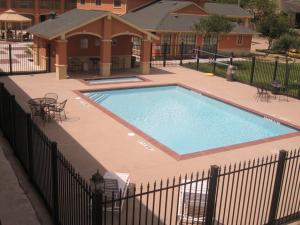 a large swimming pool in front of a house at Executive Inn Brookshire in Brookshire