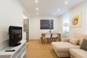 a living room with a couch and a tv at Arrasate Center - Iberorent Apartments in San Sebastián