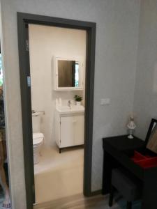ein Badezimmer mit einem WC, einem Waschbecken und einem Spiegel in der Unterkunft The Beach Residence by EHM in Nai Yang Beach