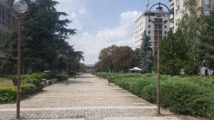 einen Fußweg in einer Stadt mit Straßenbeleuchtung und Bäumen in der Unterkunft Хотел Таганрог in Cherven Bryag