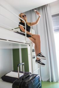 a woman jumping up into the air on top of a bunk bed at Sant Jordi Hostels Rock Palace in Barcelona