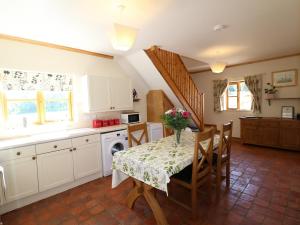 a kitchen with a table and chairs and a kitchen with a staircase at Hilltop Farm Holidays in Lincoln