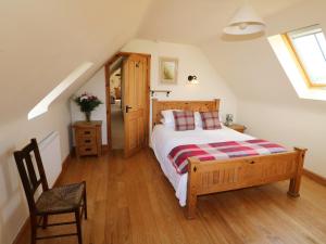 a bedroom with a bed and a chair in a attic at Hilltop Farm Holidays in Lincoln