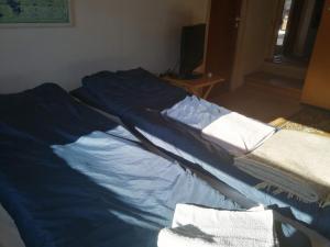 Bett mit blauer Bettwäsche in einem Zimmer in der Unterkunft Woody B&B in Jelling