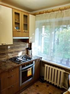 a kitchen with a stove top oven next to a window at Gerassimovi 14 apartment in Narva