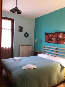 a bedroom with a large bed with blue walls at B&B A CASA DI ROSA in Caselle Torinese