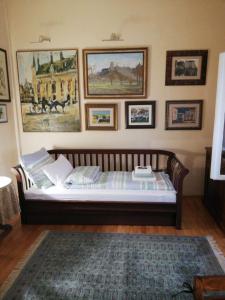 Bett in einem Zimmer mit Bildern an der Wand in der Unterkunft Classic Style Apartment in Belgrad