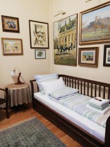 Schlafzimmer mit einem Bett und Bildern an der Wand in der Unterkunft Classic Style Apartment in Belgrad